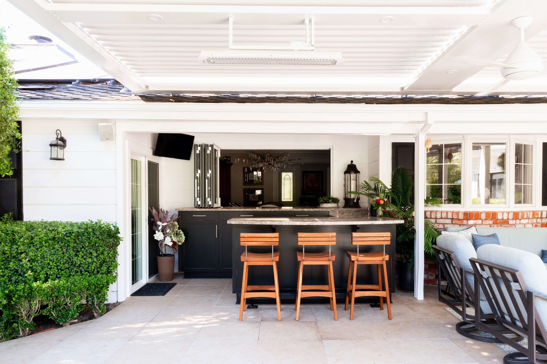 Covered outdoor kitchen and bar seating adjacent to the patio