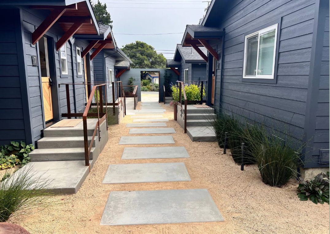 Row of blue lodge cottages with planted entries